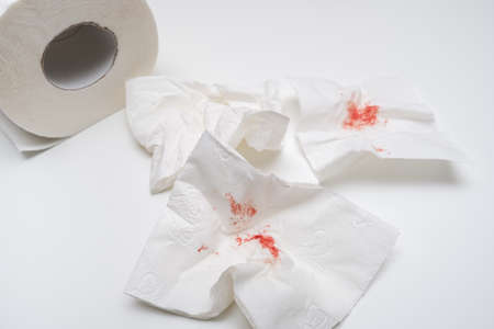 Blood on used toilet paper on white background, anal bleeding and hemorroidis conceptの写真素材