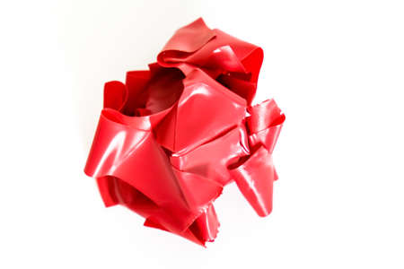 A lump of crumpled used red duct tape on white backgroundの写真素材