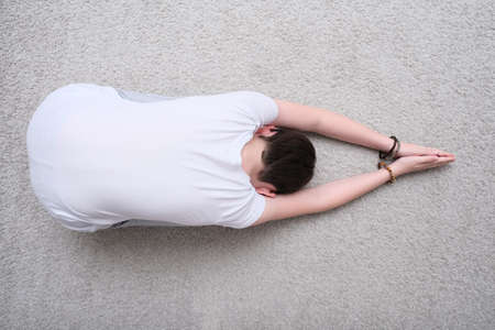 A teenager boy praying buddha on the floor at home, worship and faithの写真素材