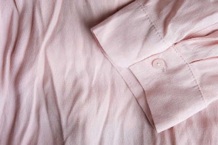 Pink pastel wrinkled blouse abstract background with cuff and buttonの写真素材