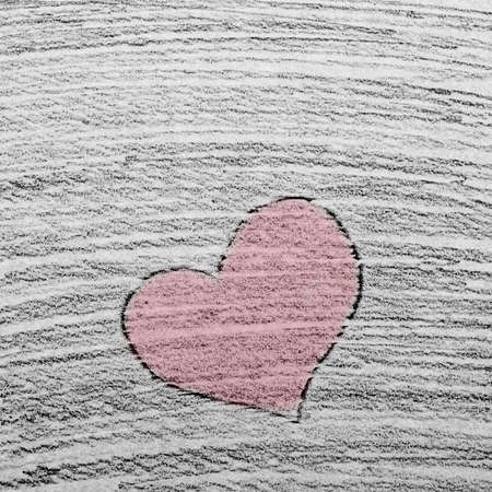 Hand drawn red heart as a symbol of love and valentines day on stroked pencil drawn backgroundの写真素材