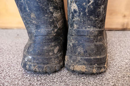 Muddy dirty rubber boots after working on construction and building.