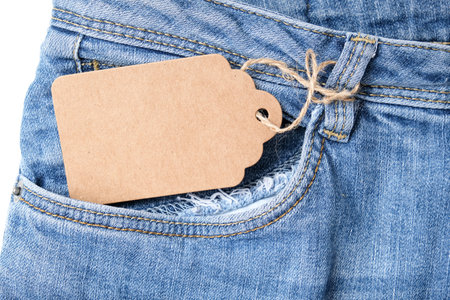 Blank craft cardboard label tag in a jeans denim pocket for sale and discount designの写真素材