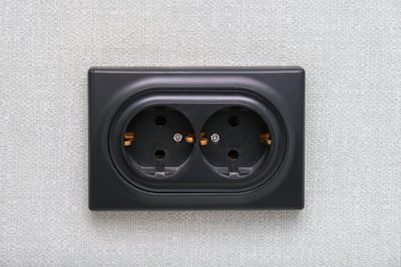 A Dual Power Outlet Installed on a Textured Wall for Enhanced Utility and Convenienceの写真素材