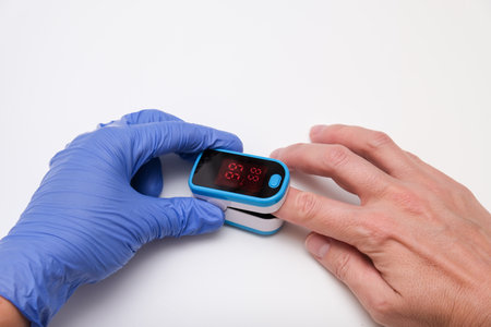 Doctor measures the patient's pulse and oxygen saturation to a patientの写真素材