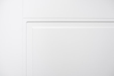 This image features a closeup view of a pristine white door set against a white wall, creating a harmonious visual effectの写真素材