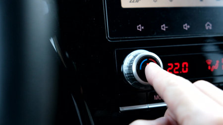 Driver hand tuning temperature control knob in car air conditioning system close up, comfort and fresh air in vehicle cabin.の写真素材