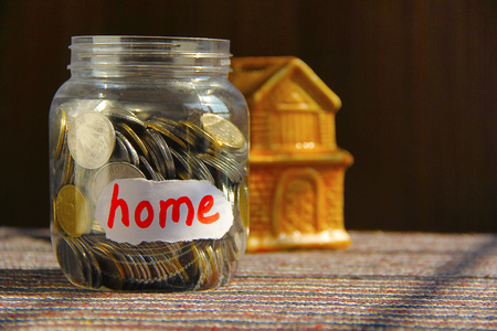 Coins in money jar with home labelの写真素材