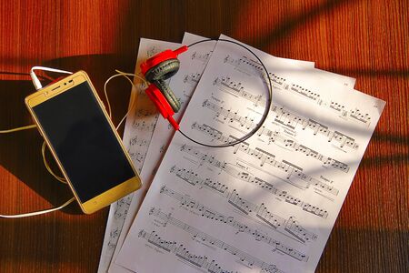 Top view mobile phone, headphone and musical notes