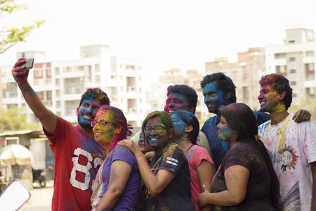 PUNE, MAHARASHTRA, INDIA, 24 March 2016. Friends with colored powder on their faces celebrating Holi...