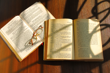 Knowledge concept Indian holy books and glasses