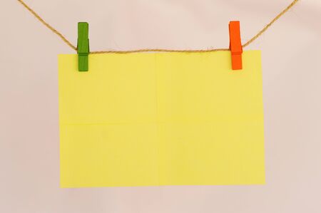 Blank sticky notes hanging with cloth pins on clothes line close viewの写真素材