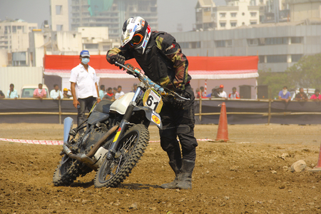 Motorcycle racer picking up his fallen motorcycle during dirt cross motorcycle race at Pune