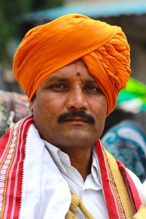 Portrait of man in orange turban. Front profile. Pandharpur festival