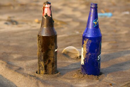 Two different color glass bottles on beach at Palande, Kokan