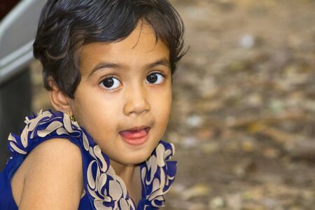 Close up of little Indian girl with her mouth open, Empress garden at Puneの写真素材
