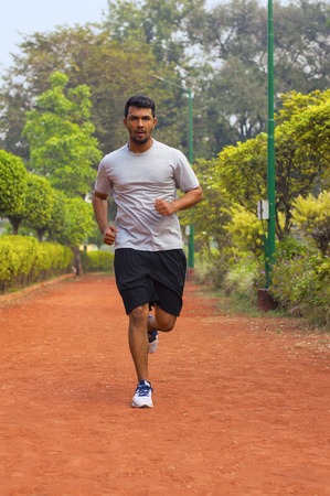 Young and handsome guy running on a jogging track