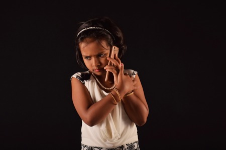 Little girl talking to someone on mobile phone, Pune, Maharashtraの写真素材