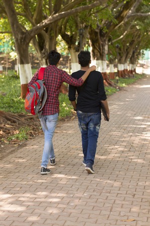 Two young students going to college and on shoulder, back poseの写真素材