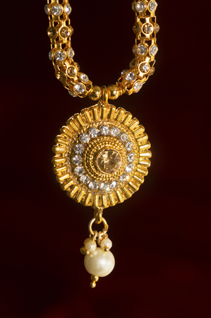 Close-up of artificial necklace on red backgroundの写真素材