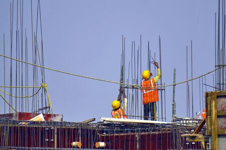Construction workers working on a building column.の写真素材