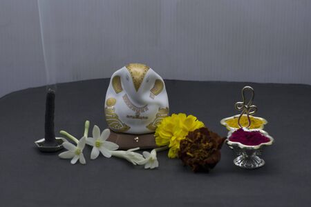Ganesha with flowers and incense stick, typical traditional Hindu pooja