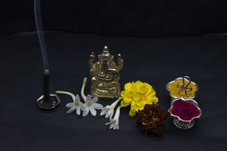 Ganesha with flowers and incense stick, typical traditional Hindu pooja