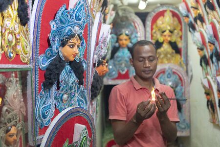 KUMARTULI, KOLKATA, INDIA, February 2012, Artisan lighting incense stick for worshipのeditorial素材