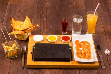 Chicken cooked on hot lava stone with saucesの写真素材