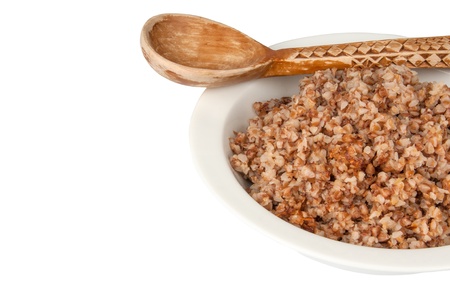 buckwheat in a white bowl and wooden spoonの写真素材