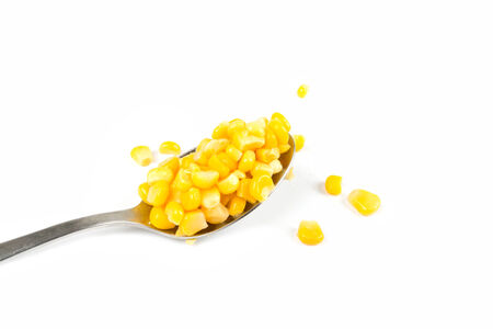 Spoon with corn on a white backgroundの写真素材