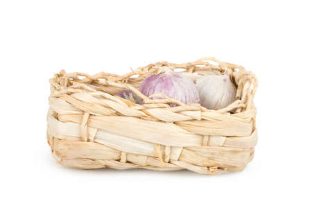 Organic garlic in a small basket on a white backgroundの写真素材