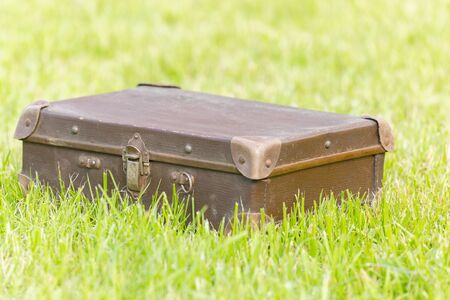 Old brown suitcase on grassの写真素材