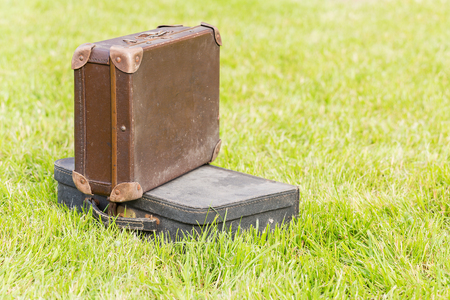 two old suitcase blue and brown on the grassの写真素材