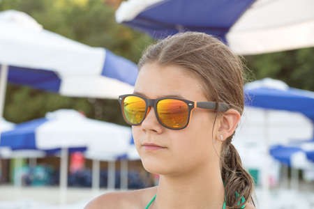 Girl in sunglasses at sea looking into the distanceの写真素材