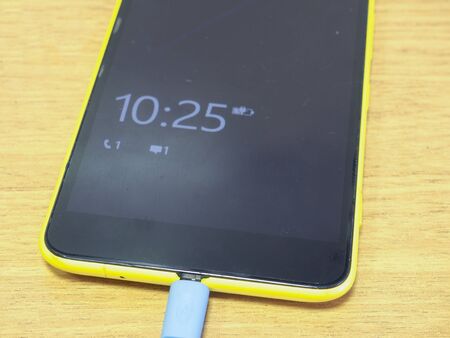 smartphone charged on the wooden table