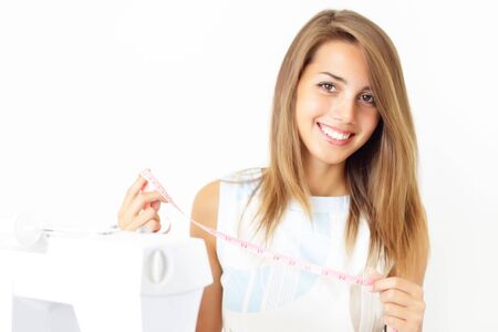 Girl and a sewing machine on a light backgroundの写真素材