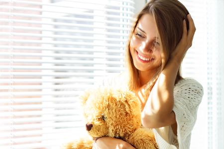 Smiling girl sitting by the windowの写真素材