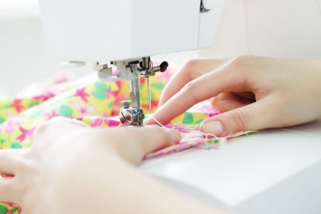 Fabric in a sewing machine on a light background