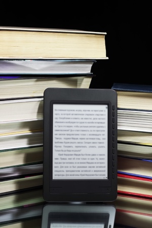 Ebook reader against the background of a stack booksの写真素材