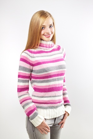 Portrait of pretty girl wearing sweater on a gray backgroundの写真素材