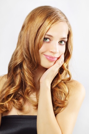 Beautiful girl with long wavy hair on a gray backgroundの写真素材