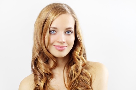 Beautiful girl with long wavy hair on a gray backgroundの写真素材