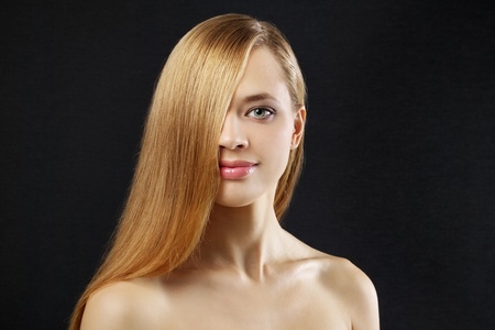 Attractive girl with beautiful, straight hair on a dark backgroundの写真素材