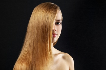 Attractive girl with beautiful, straight hair on a dark backgroundの写真素材