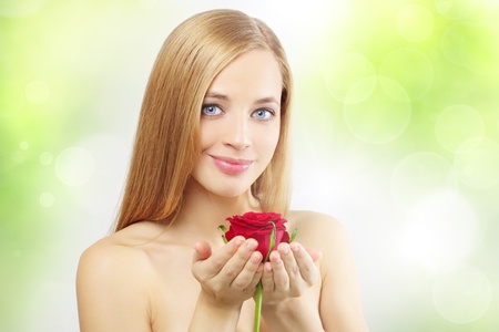 beautiful girl with red rose on a green backgroundの写真素材