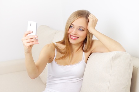 girl holding a mobile phone on light backgroundの写真素材
