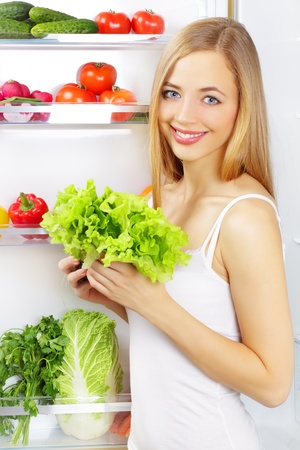 girl with a green salad  Background of the refrigeratorの写真素材