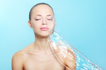Beautiful girl and stream of water on a blue backgroundの写真素材
