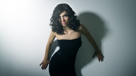 Beautiful girl in black dress on light backgroundの写真素材